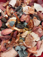 A collection of dried herbs and roots, including pieces of turmeric, ginger, and black pepper.